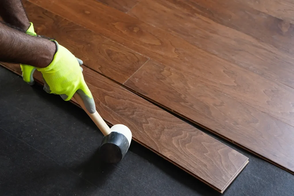 Installer fitting new white oak hardwood flooring in a Durham, NC home